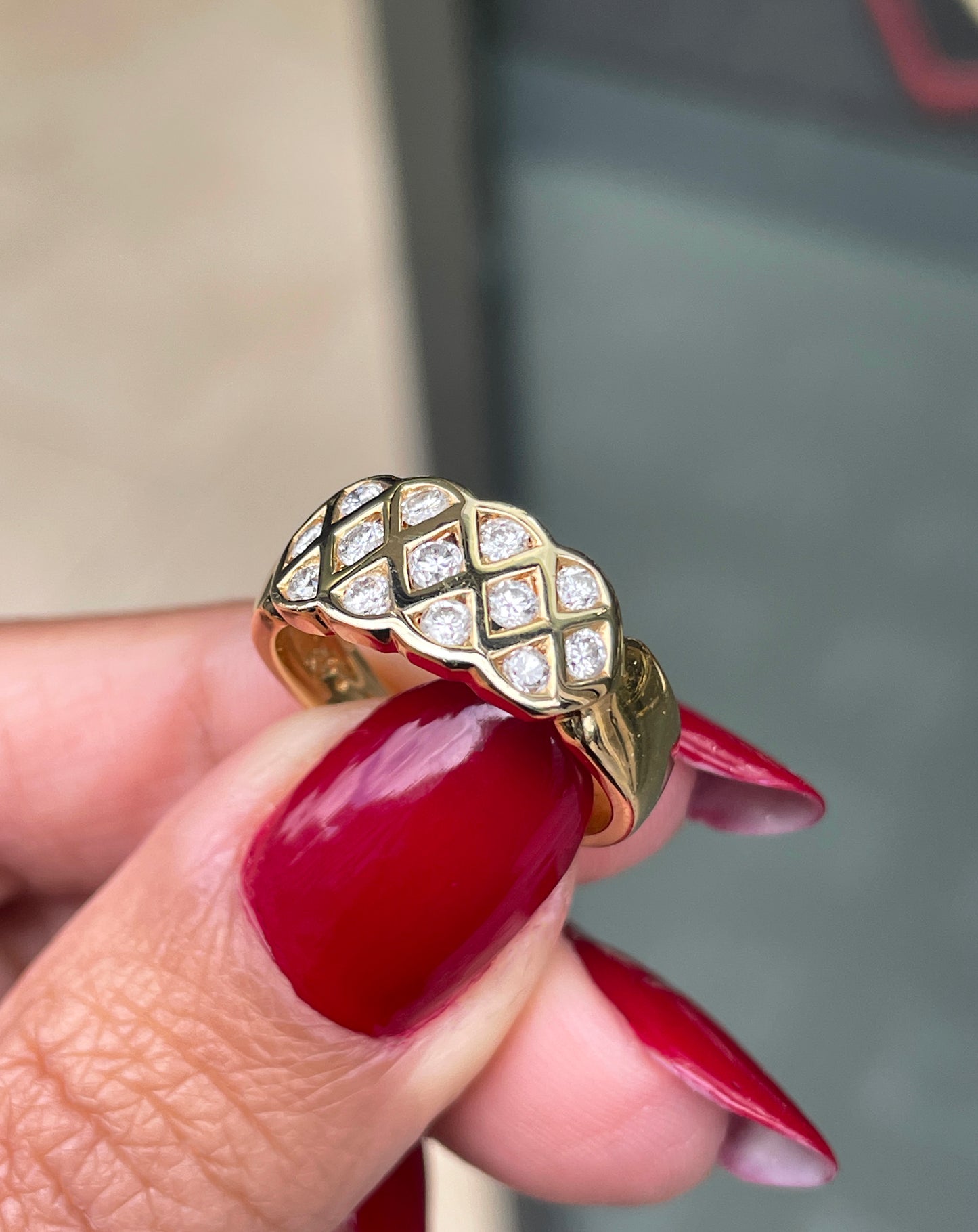 An 18 carat yellow gold lattice band ring with round brilliant cut diamond on hand