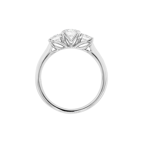 A platinum engagement ring with a central round brilliant cut diamond and two smaller round cut diamonds on the sides, set in an open-work gallery. Side view.