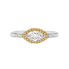 A marquise diamond engagement ring with a halo of round yellow diamonds set in rose gold, with smaller white round brilliant cut diamonds set in a contrasting band of platinum.