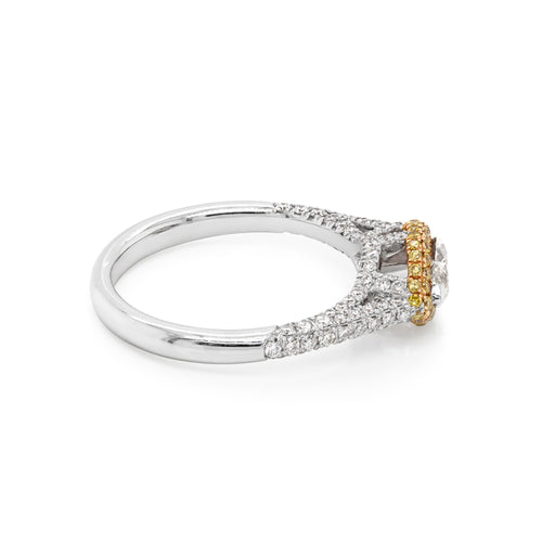 A marquise diamond engagement ring with a halo of round yellow diamonds set in rose gold, with smaller white round brilliant cut diamonds set in a contrasting band of platinum. side view