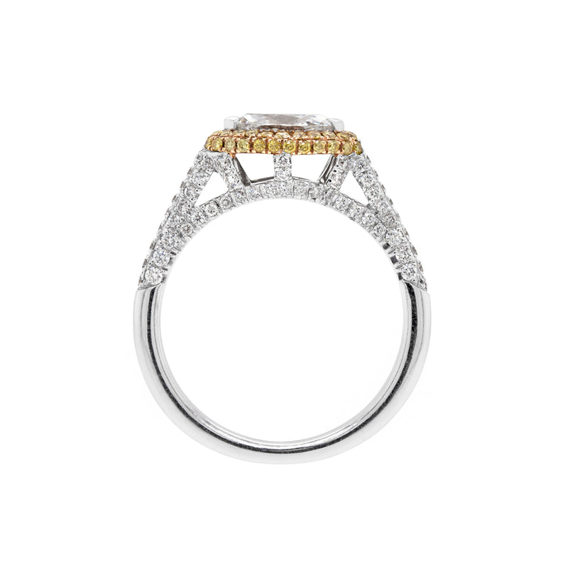 A marquise diamond engagement ring with an east west setting  halo of round yellow diamonds set in rose gold, with smaller white round brilliant cut diamonds set in a contrasting band of platinum. side view