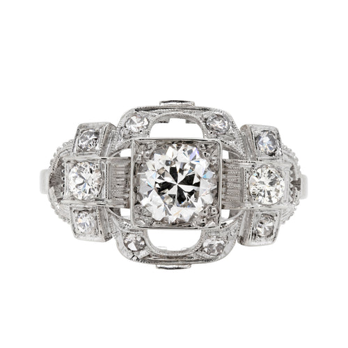 An Art Deco style engagement ring with a central old cut diamond and additional diamonds set in a platinum mount with open work detailing.