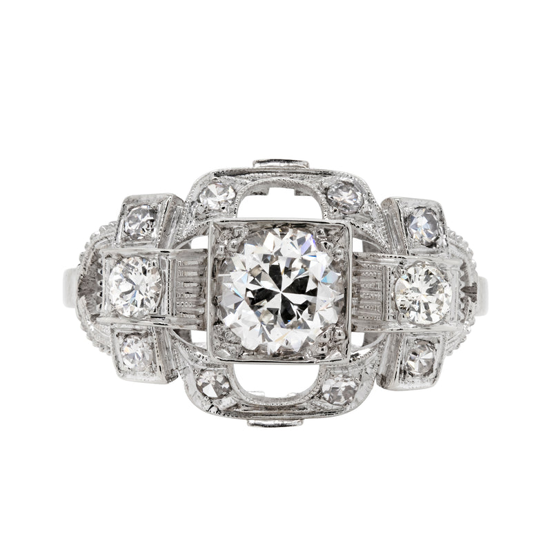 An Art Deco style engagement ring with a central old cut diamond and additional diamonds set in a platinum mount with open work detailing.