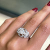 An Art Deco style engagement ring with a central old cut diamond and additional diamonds set in a platinum mount with open work detailing on hand