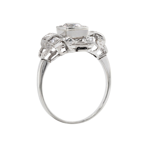 An Art Deco style engagement ring with a central old cut diamond and additional diamonds set in a platinum mount with open work detailing