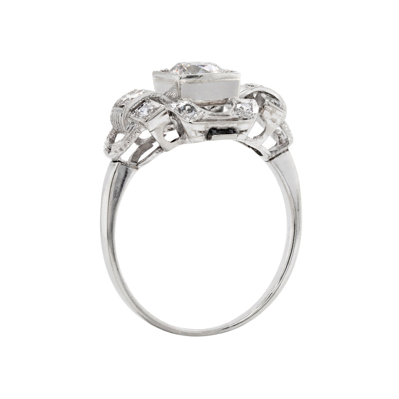 An Art Deco style engagement ring with a central old cut diamond and additional diamonds set in a platinum mount with open work detailing