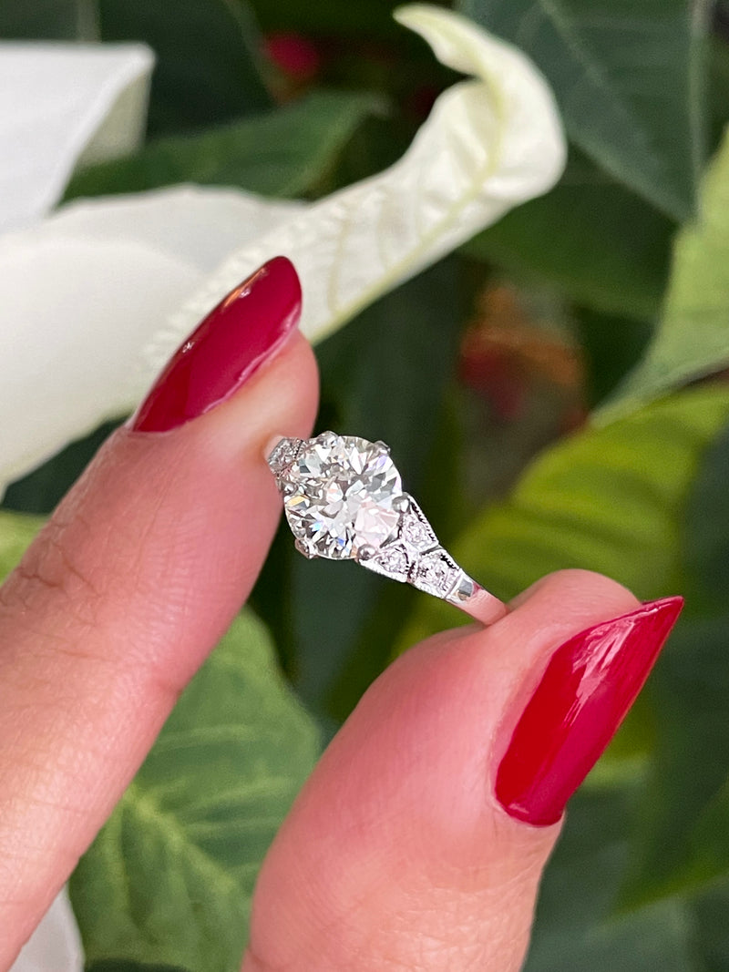 a 0.95 Carat Old Cut Diamond Engagement Ring with 6 smaller diamonds set in Platinum on hand