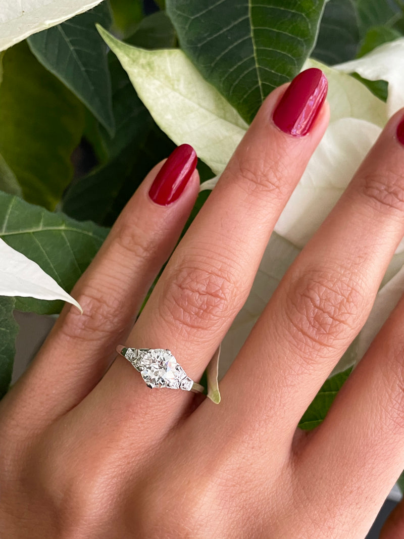 a 0.95 Carat Old Cut Diamond Engagement Ring with 6 smaller diamonds set in Platinum on hand