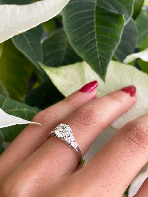 a 0.95 Carat Old Cut Diamond Engagement Ring with 6 smaller diamonds set in Platinum on hand