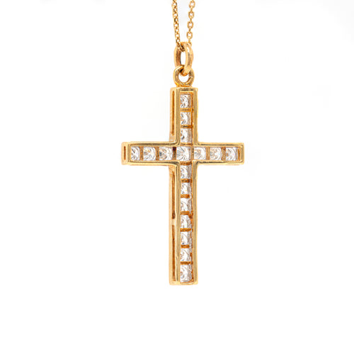 An 18 carat yellow gold diamond cross pendant with multiple round brilliant cut diamonds set within it.