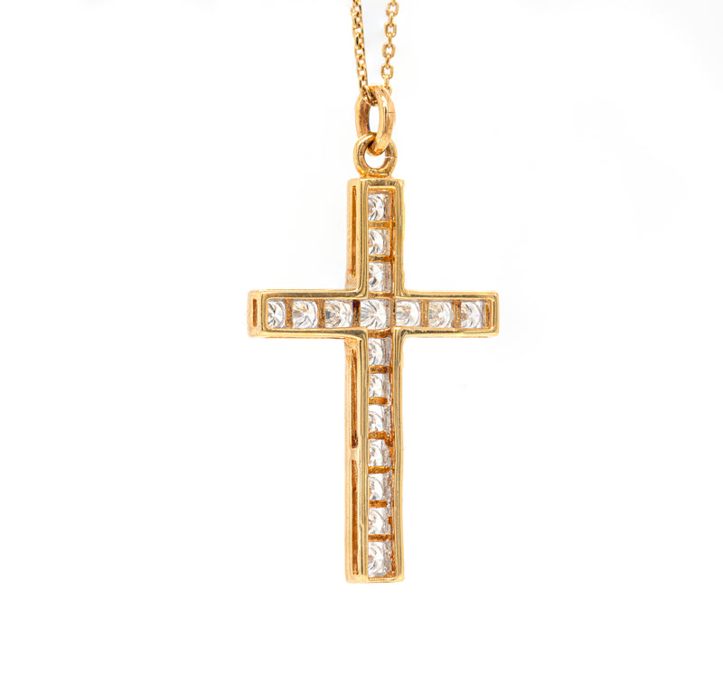 An 18 carat yellow gold diamond cross pendant with multiple round brilliant cut diamonds set within it.
