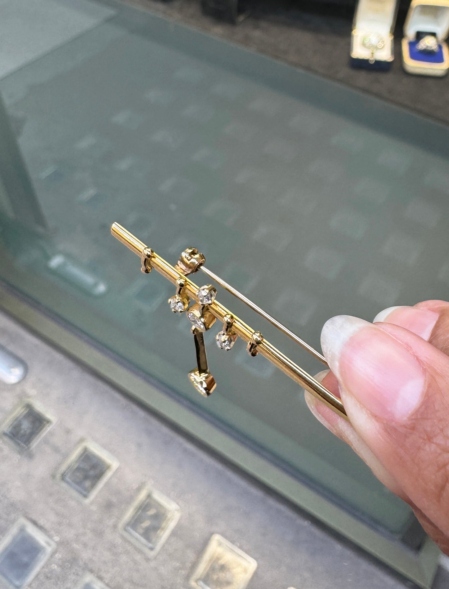 An 18 carat yellow gold bar brooch with five round brilliant cut diamonds attached to it