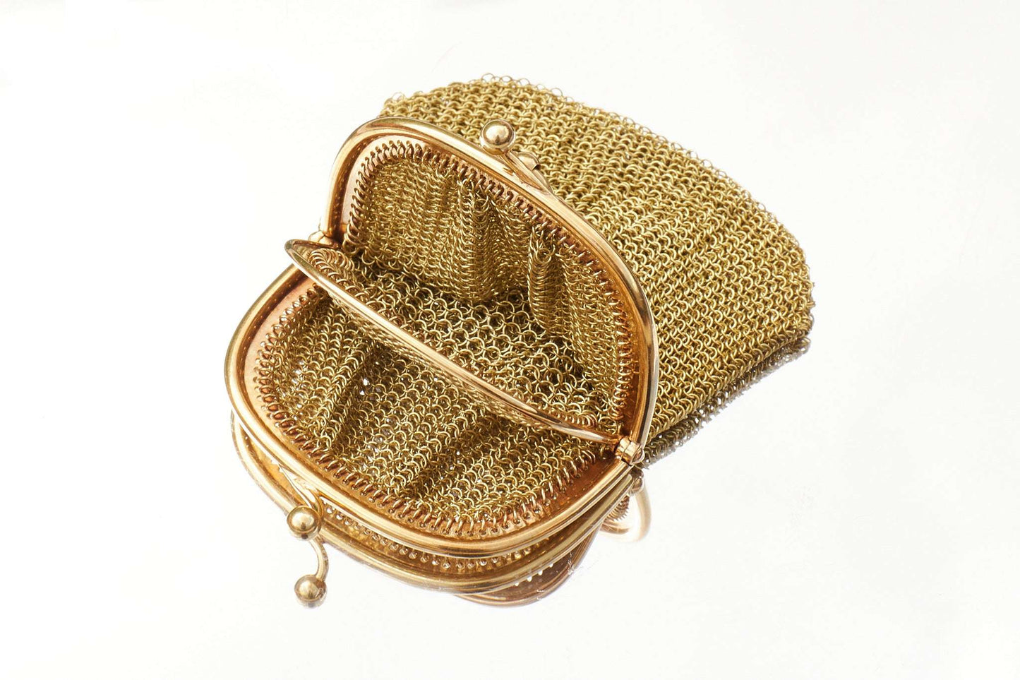 Gold mesh handbag on a white background