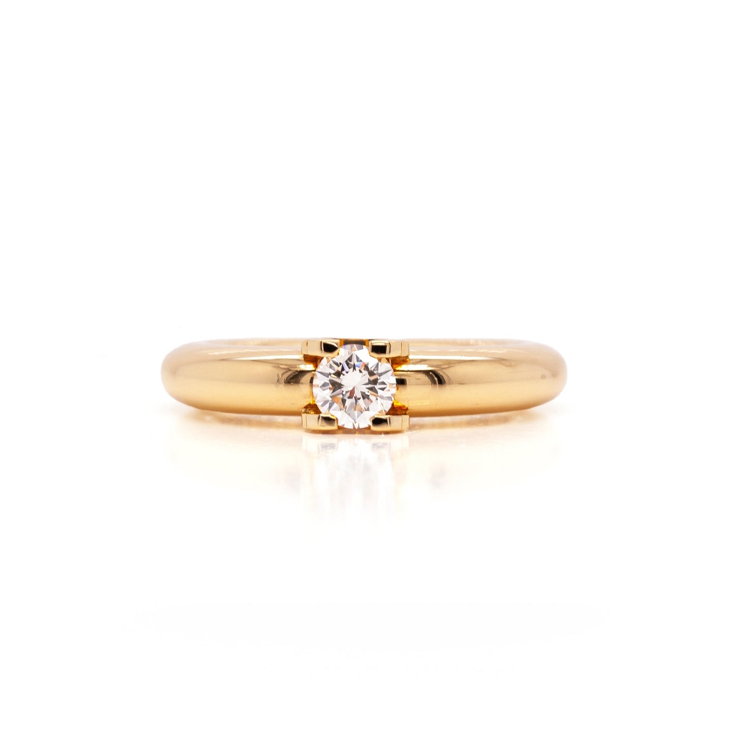 An 18 carat yellow gold Cartier 'C de Cartier' diamond solitaire engagement ring with a round brilliant cut center diamond.