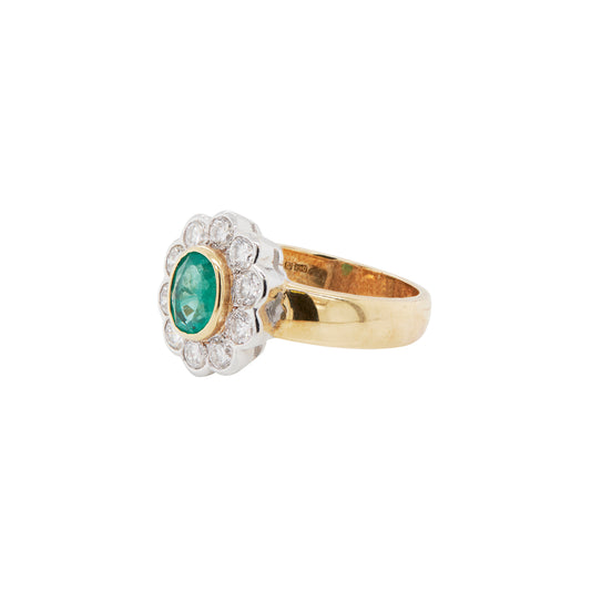 Gold ring with an emerald and diamond accents on a white background