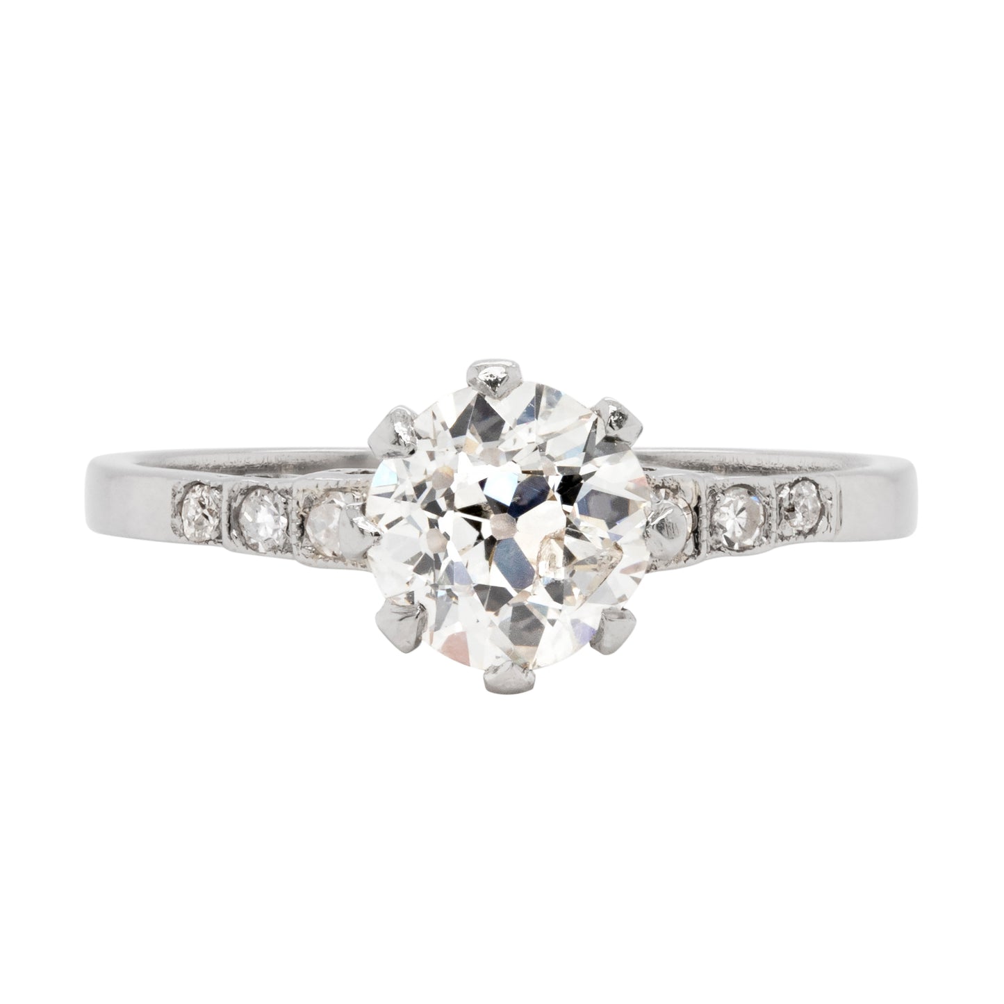 Antique engagement ring with a central old cut diamond and smaller diamonds on the sides, set in a platinum mounting with an open back design.