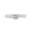 An 18 carat white gold engagement ring with a round brilliant cut diamond centerpiece and additional round brilliant cut diamonds set on either side.