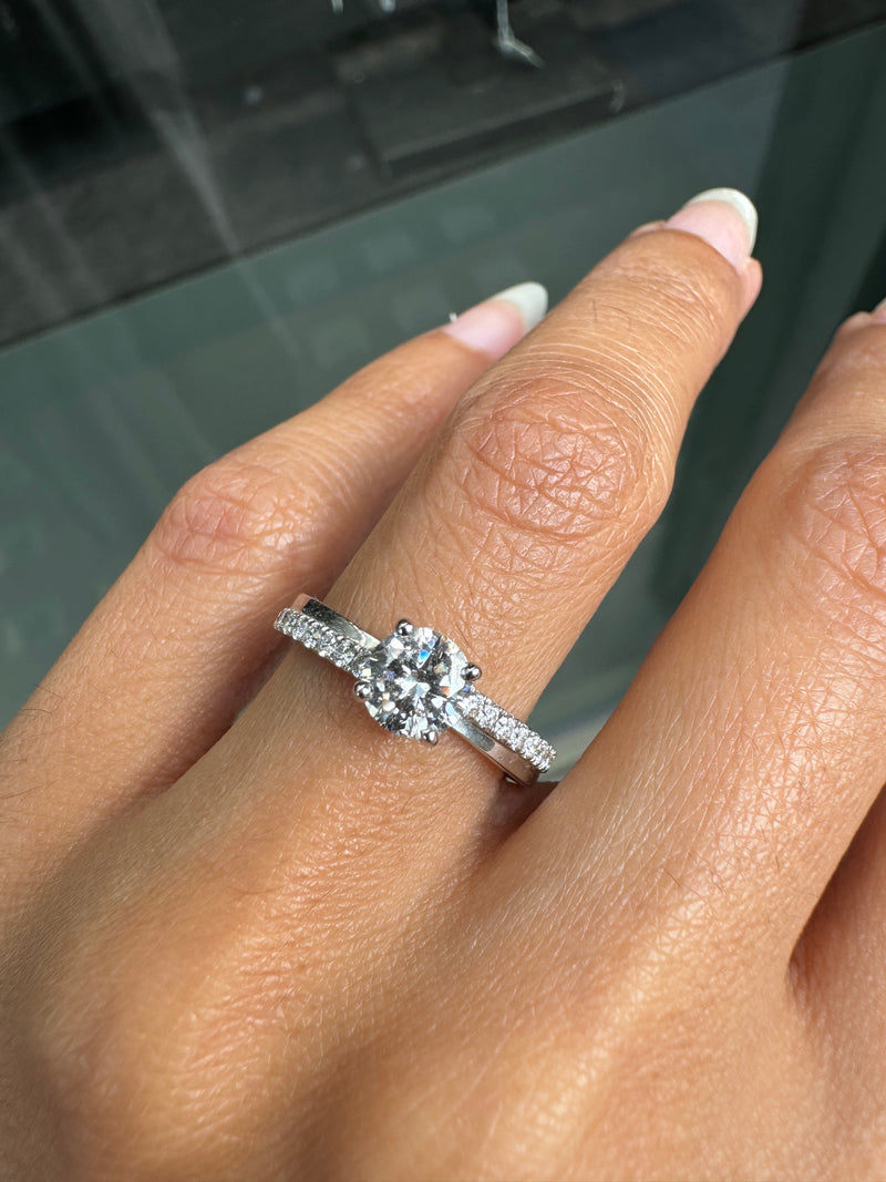 Close-up of a hand wearing a diamond ring with a blurred background