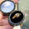 A 18 carat yellow gold vintage gypsy ring with a central old mine cut diamond, surrounded by smaller clear stones set in a raised eight claw, open back setting in its case