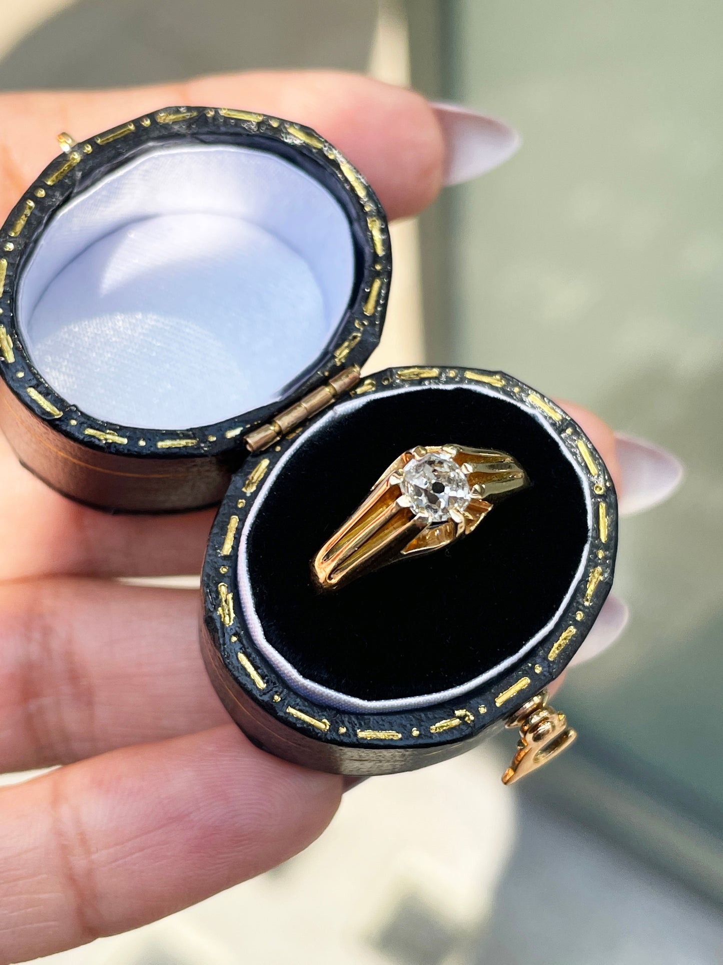 A 18 carat yellow gold vintage gypsy ring with a central old mine cut diamond, surrounded by smaller clear stones set in a raised eight claw, open back setting in its case
