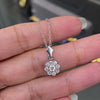 Video of a 0.45 carat diamond flower cluster pendant crafted in 18 carat white gold, round brilliant cut diamonds arranged in a floral design, suspended from a delicate white gold chain. on hand