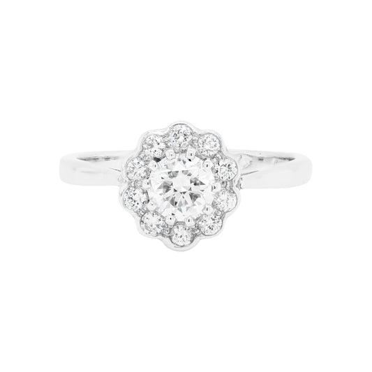 A round brilliant cut diamond ring with smaller round brilliant cut diamonds set in a daisy cluster design, mounted in a platinum band.