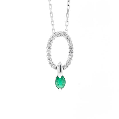 An 18 carat white gold oval pendant featuring a central emerald, surrounded by round brilliant cut diamonds set in a claw-like design.