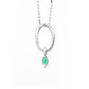 Back of An 18 carat white gold oval pendant featuring a central emerald, surrounded by round brilliant cut diamonds set in a claw-like design.