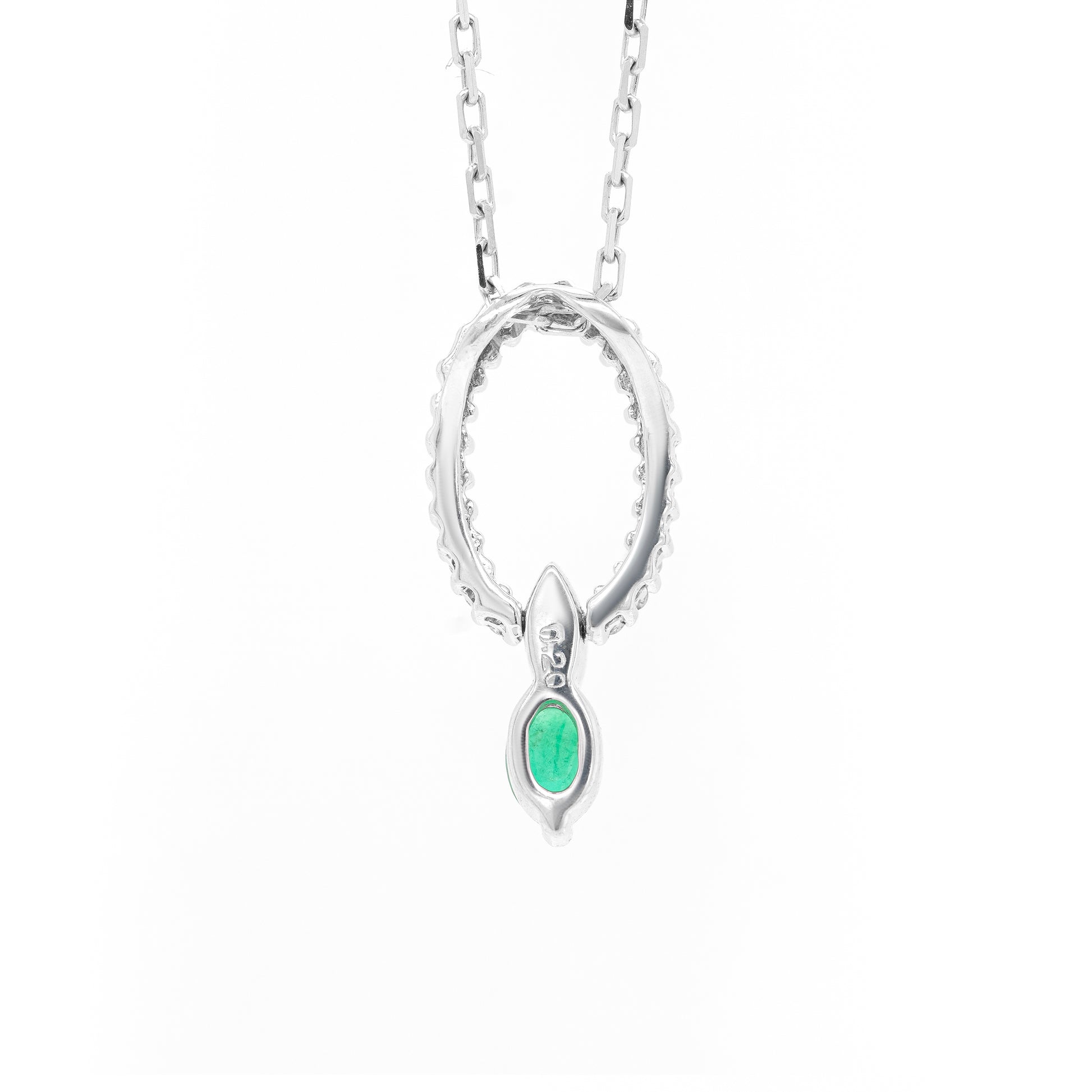 Back of An 18 carat white gold oval pendant featuring a central emerald, surrounded by round brilliant cut diamonds set in a claw-like design.