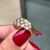 An 18 carat yellow gold lattice band ring with round brilliant cut diamond on hand