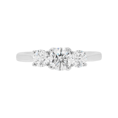 A platinum engagement ring with a central round brilliant cut diamond and two smaller round cut diamonds on the sides, set in an open-work gallery.