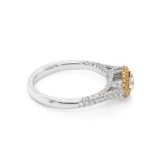 A marquise diamond engagement ring with a halo of round yellow diamonds set in rose gold, with smaller white round brilliant cut diamonds set in a contrasting band of platinum. side view