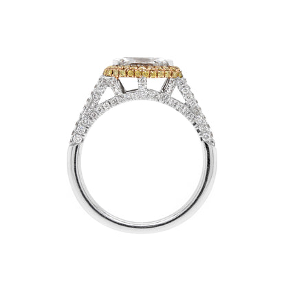 A marquise diamond engagement ring with an east west setting  halo of round yellow diamonds set in rose gold, with smaller white round brilliant cut diamonds set in a contrasting band of platinum. side view