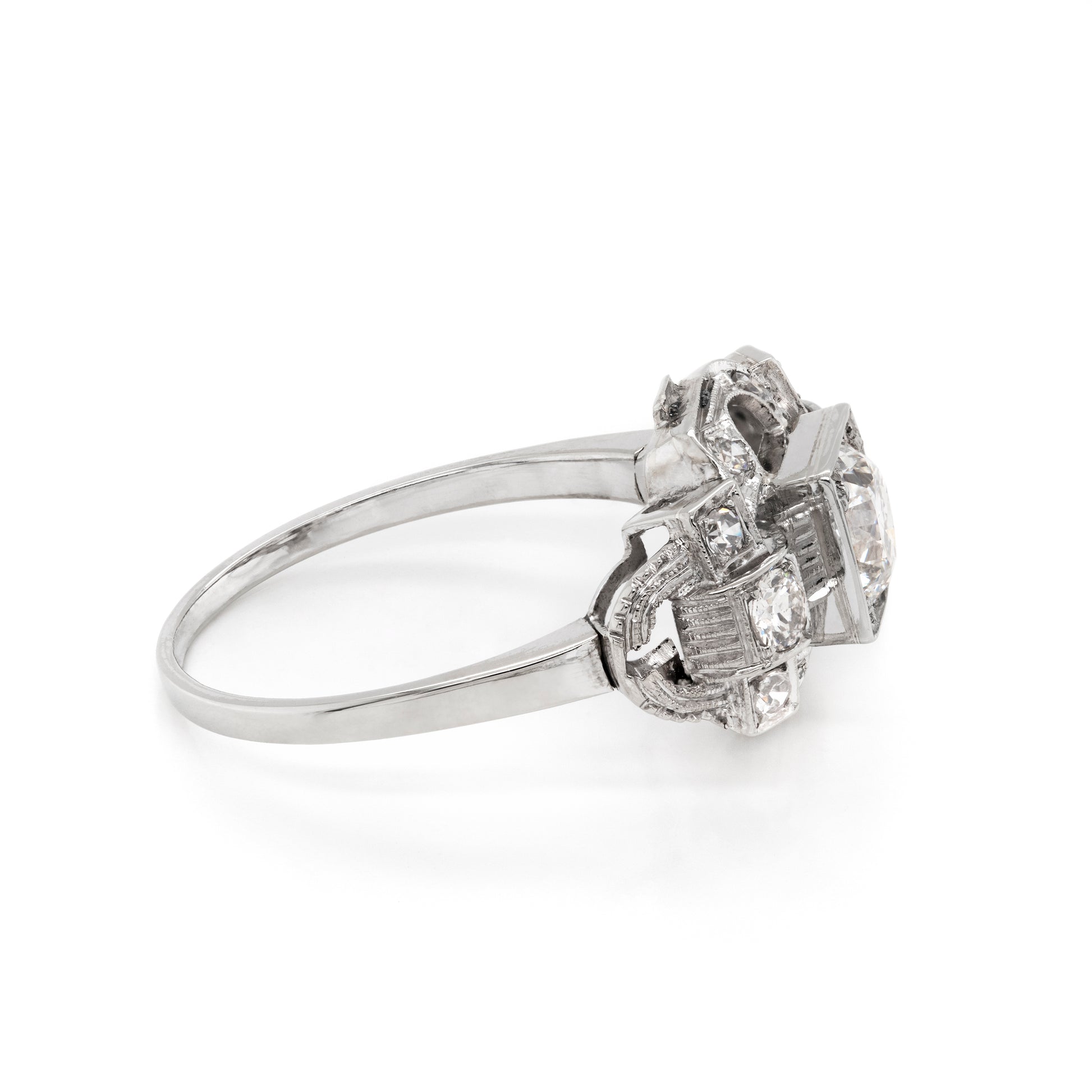 An Art Deco style engagement ring with a central old cut diamond and additional diamonds set in a platinum mount with open work detailing 