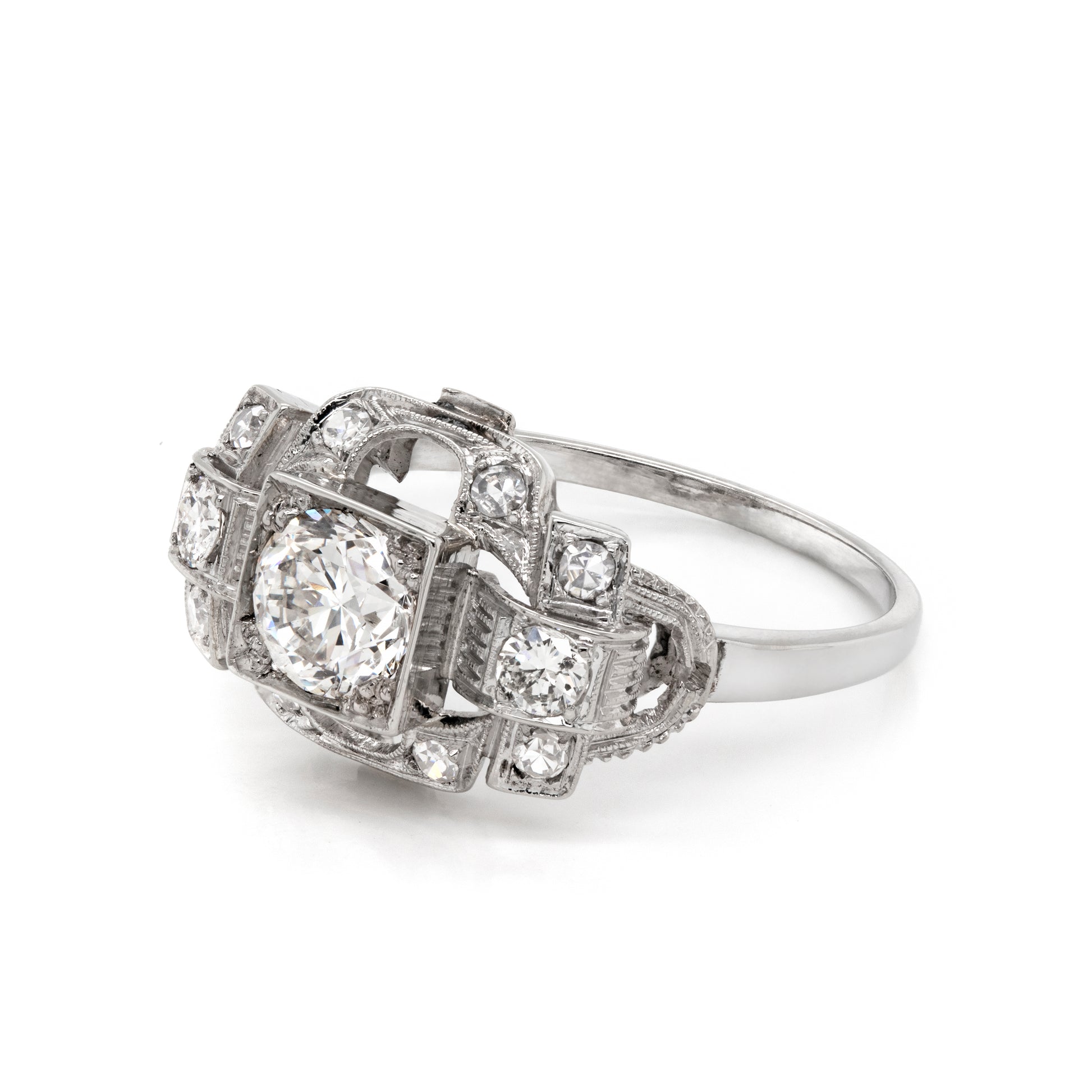 An Art Deco style engagement ring with a central old cut diamond and additional diamonds set in a platinum mount with open work detailing 