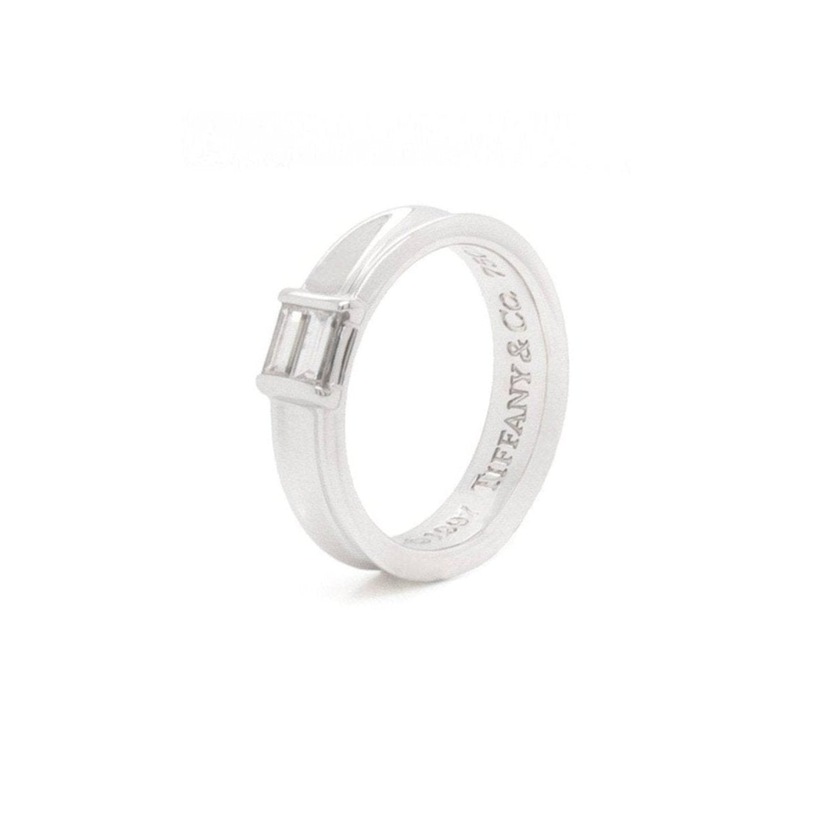A Tiffany & Co. white gold band ring with baguette cut diamonds, featuring a polished finish and a concave design on the outer side.