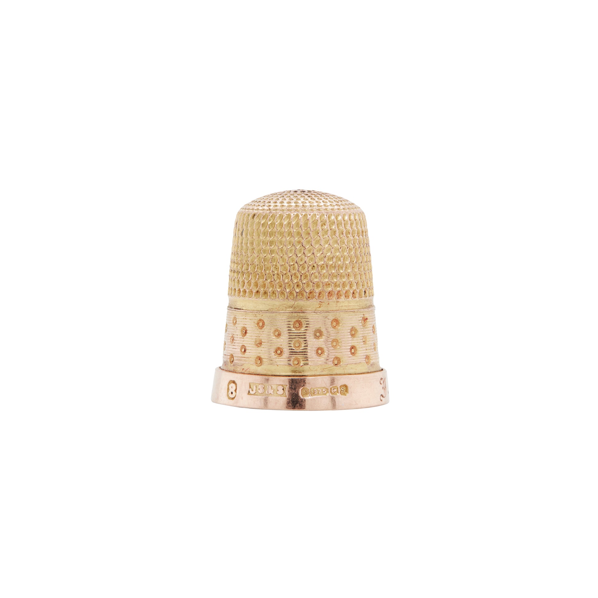 Antique engraved thimble made of rose and yellow gold, displaying textured patterns on the top and decorative ribbed and polka dot patterns around the band.