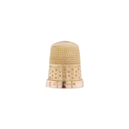Antique engraved thimble made of rose and yellow gold, displaying textured patterns on the top and decorative ribbed and polka dot patterns around the band.