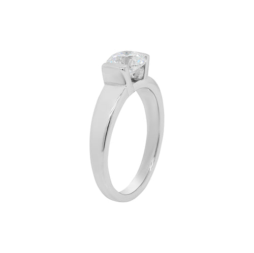 A white gold engagement ring with a round brilliant cut diamond centerpiece, set in a tapered platinum band.