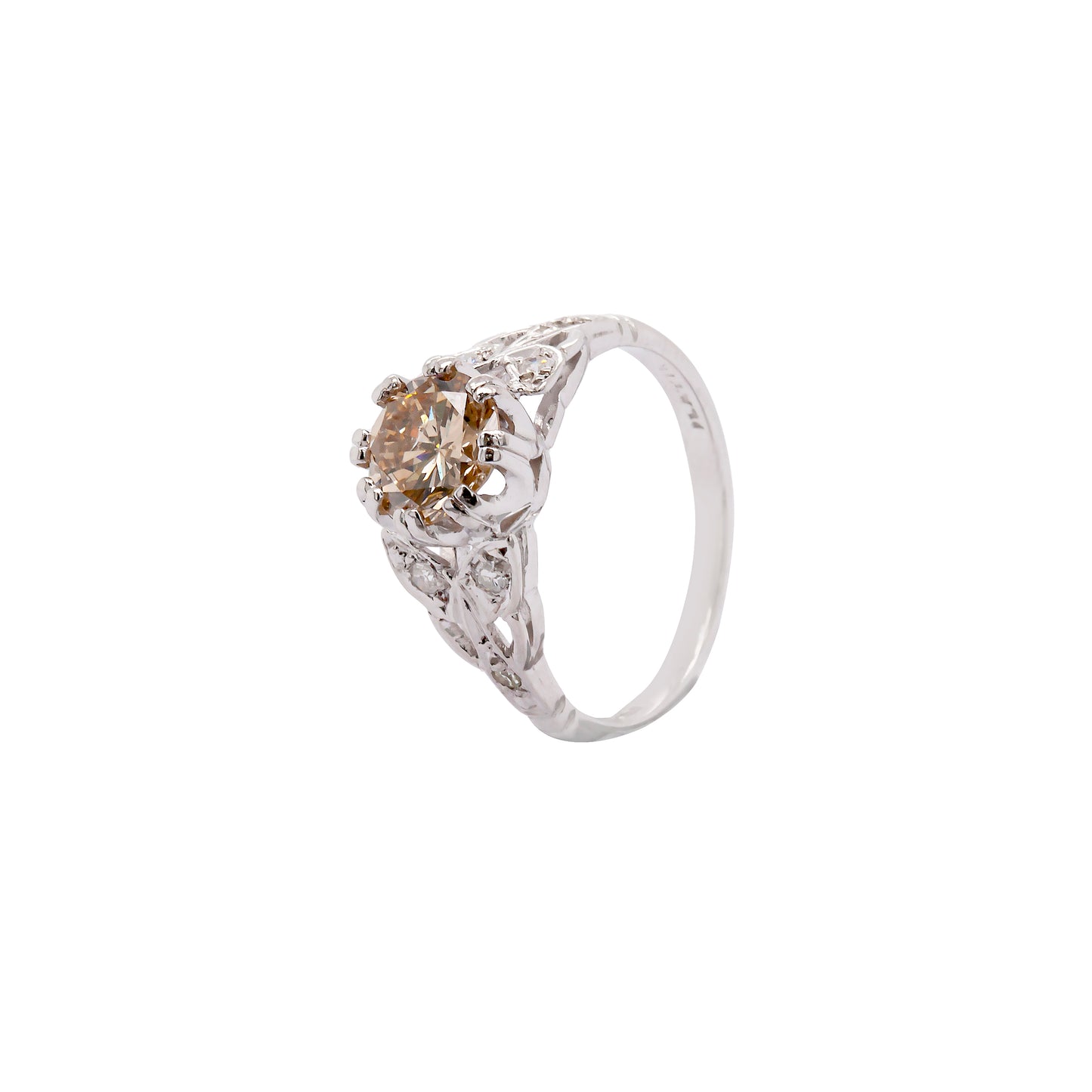 A vintage platinum engagement ring with a central 1.18ct fancy brown round brilliant cut diamond and three rose cut diamonds on either side, set in leaf designed pierced shoulders.