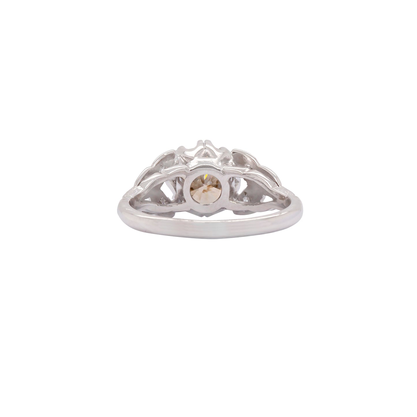 A vintage platinum engagement ring with a central 1.18ct fancy brown round brilliant cut diamond and three rose cut diamonds on either side, set in leaf designed pierced shoulders.