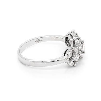 An 18 carat white gold trilogy diamond cluster engagement ring with three circular diamond clusters and a princess cut diamond in the center, set in a white gold band.