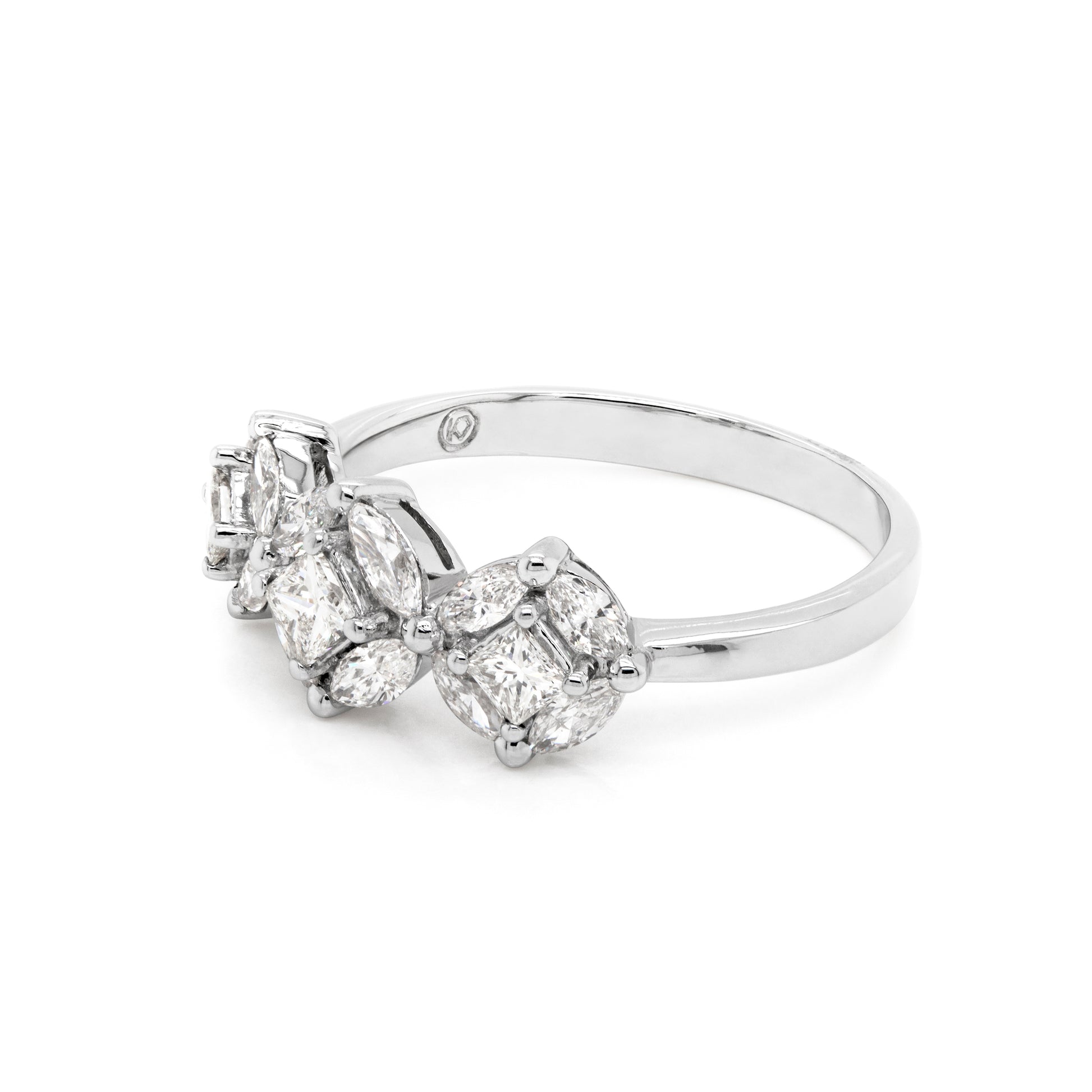 An 18 carat white gold trilogy diamond cluster engagement ring with three circular diamond clusters and a princess cut diamond in the center, set in a white gold band.