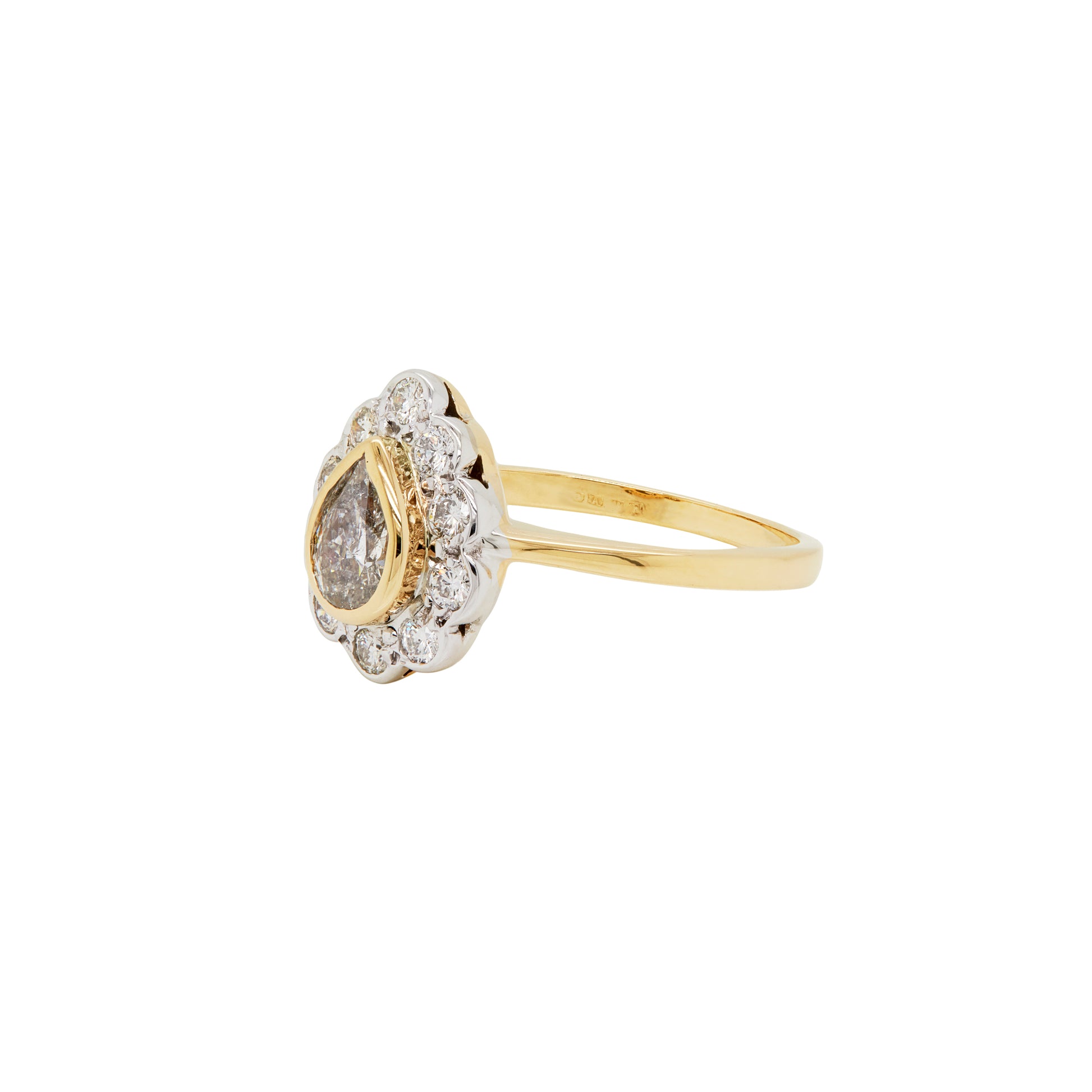 An 18 carat white and yellow gold pear shape diamond coronet cluster engagement ring with a central diamond surrounded by a halo of round brilliant cut diamonds.