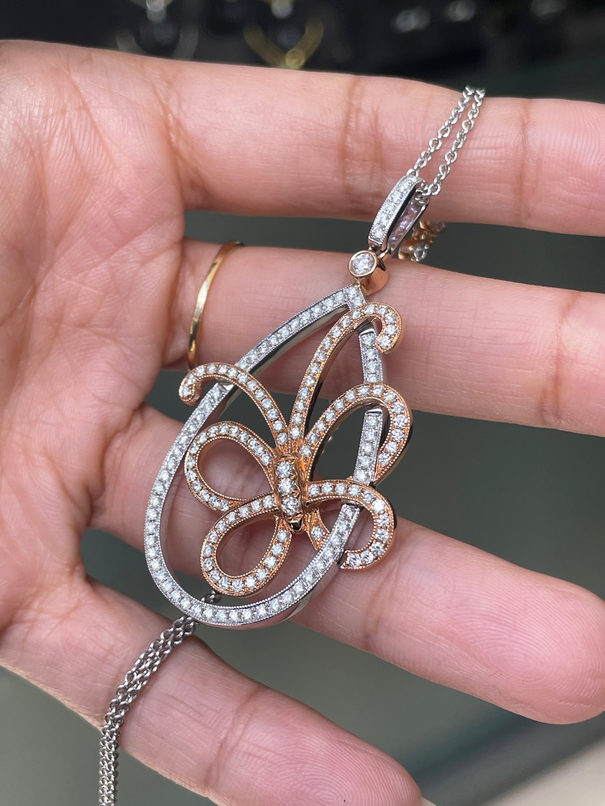 An 18 carat white and rose gold diamond butterfly pendant with a chain.