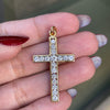 An 18 carat yellow gold diamond cross pendant with multiple round brilliant cut diamonds set within it.