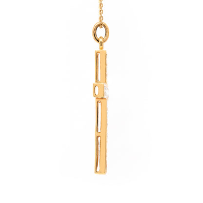An 18 carat yellow gold diamond cross pendant with multiple round brilliant cut diamonds set within it.