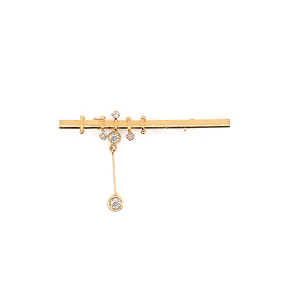 An 18 carat yellow gold bar brooch with five round brilliant cut diamonds attached to it, displayed against a white background.