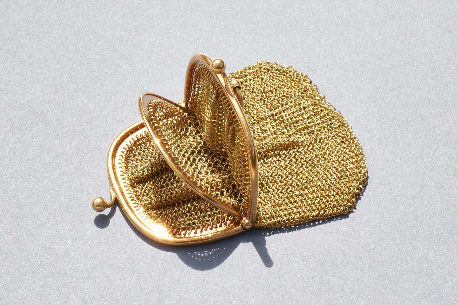 Gold mesh handbag on a light gray background