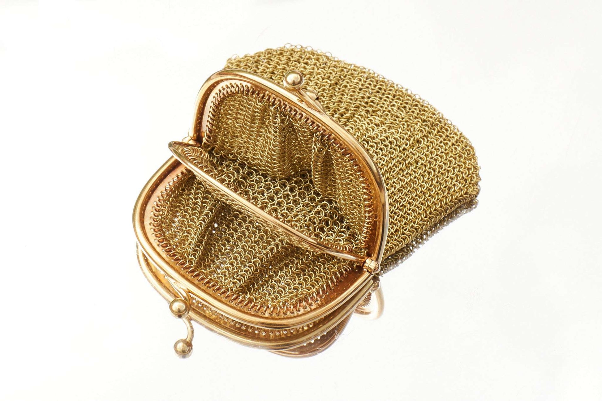 Gold mesh handbag on a white background